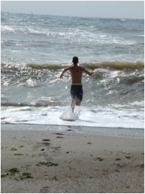 guy running into the waves at the beach