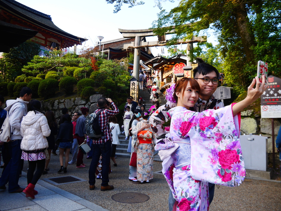 japanese couple taking a selfie at Kyoto Jishu Shrine